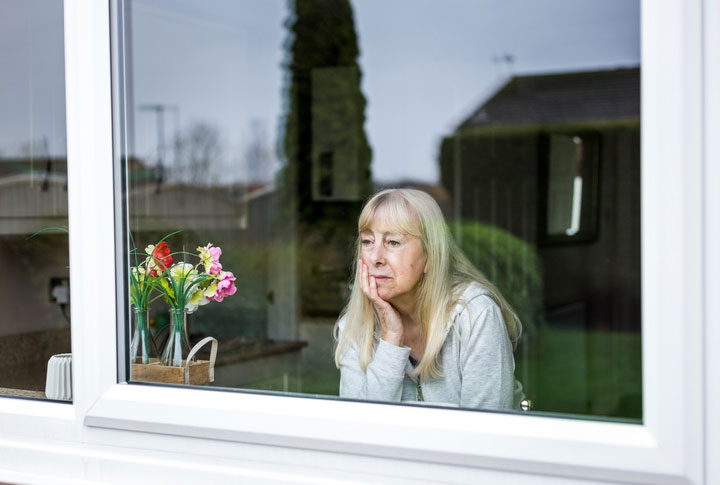 depressed elderly woman in a window