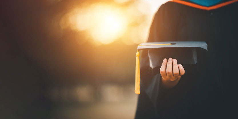 grad holding their cap