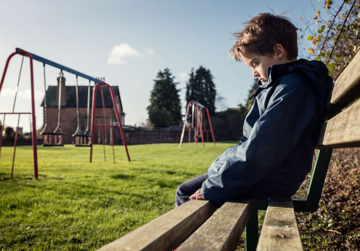 lonely child alone on a park bench