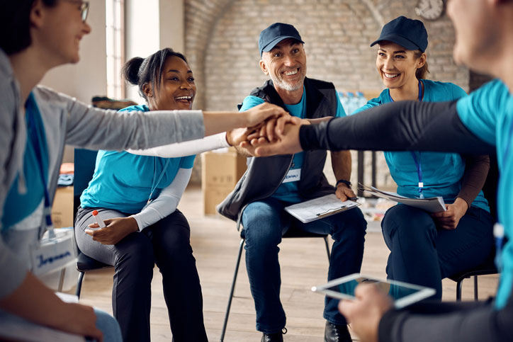 group gathering hands in meeting