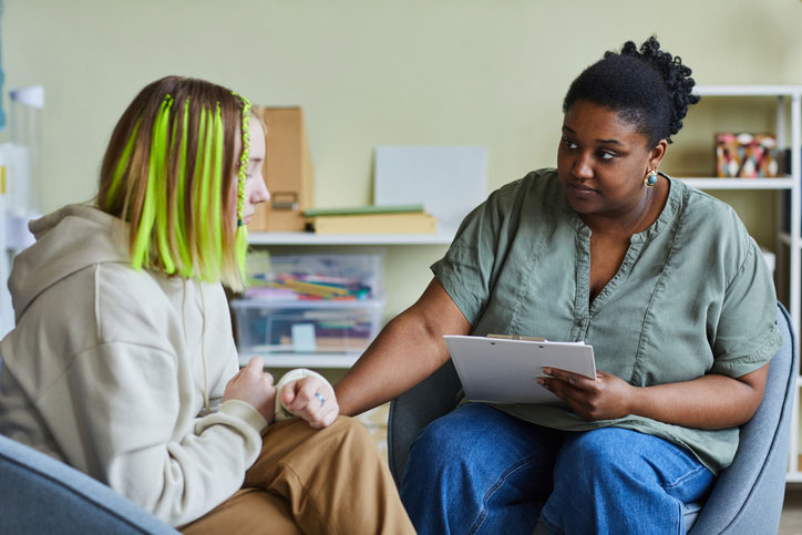 student with school social worker in office