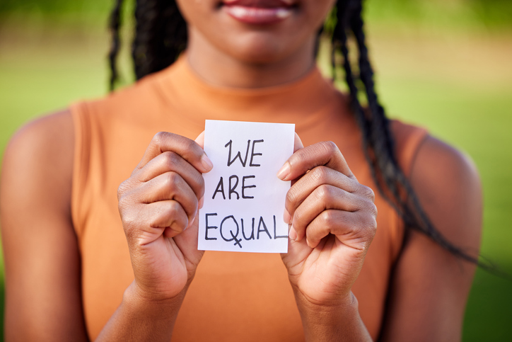 young woman holding a we are equal